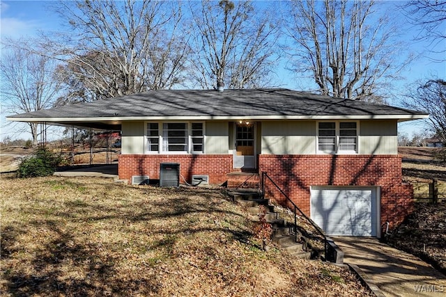 view of front of home featuring brick siding, a garage, an attached carport, central AC unit, and driveway