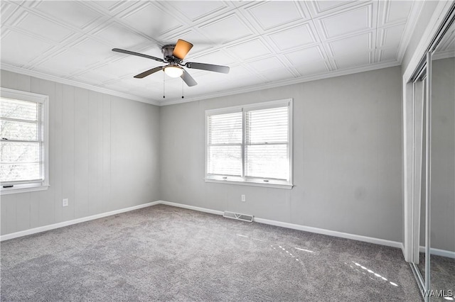 carpeted empty room featuring crown molding, a healthy amount of sunlight, and ceiling fan