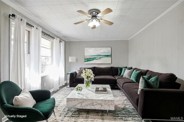 living area featuring ornamental molding and a ceiling fan