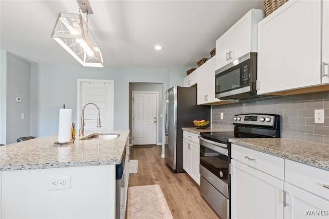 320 Rob Lee St, Moundville, AL 35474 - kitchen featuring appliances with stainless steel finishes, an island with sink, light wood-style flooring, tasteful backsplash, and recessed lighting