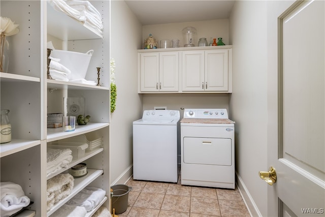 laundry area with cabinets, light tile patterned floors, and washing machine and dryer