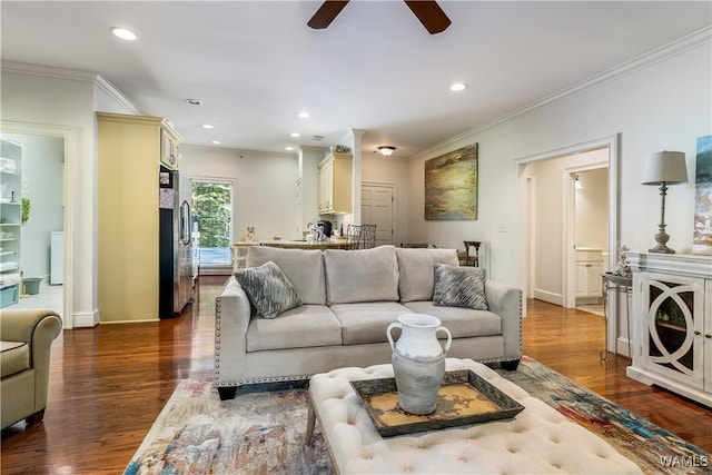 living room featuring hardwood / wood-style flooring, ceiling fan, and ornamental molding