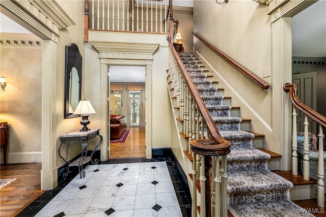 staircase featuring hardwood / wood-style floors and ornamental molding