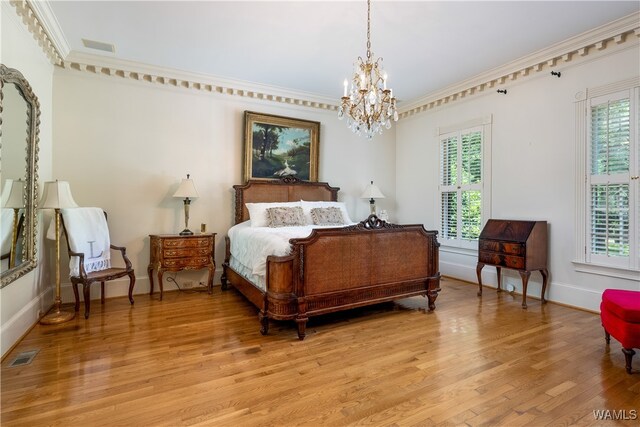 bedroom featuring a notable chandelier, light wood-type flooring, and crown molding