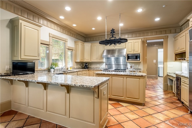 kitchen featuring cream cabinetry, stainless steel microwave, kitchen peninsula, and crown molding