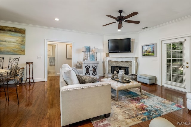 living room with ceiling fan, a fireplace, dark hardwood / wood-style floors, and ornamental molding