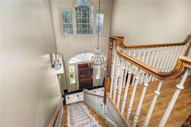 stairway featuring hardwood / wood-style flooring and a notable chandelier