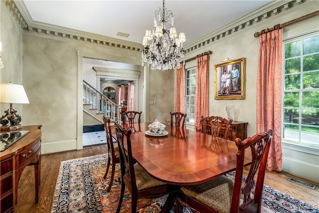 dining space with crown molding, hardwood / wood-style floors, a chandelier, and plenty of natural light