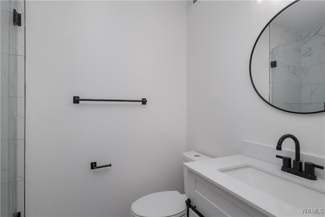 full bath featuring vanity, a shower stall, and toilet