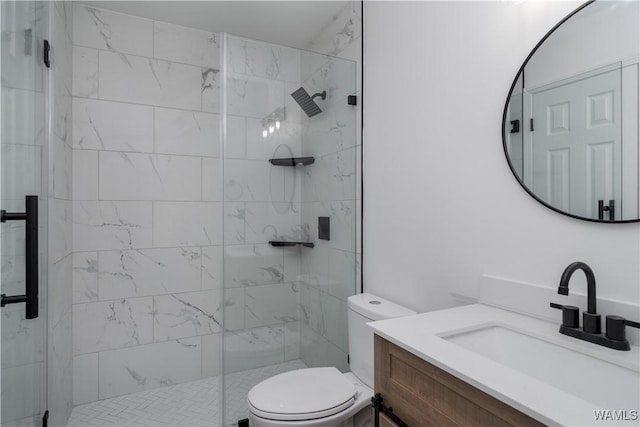 bathroom featuring toilet, a stall shower, and vanity