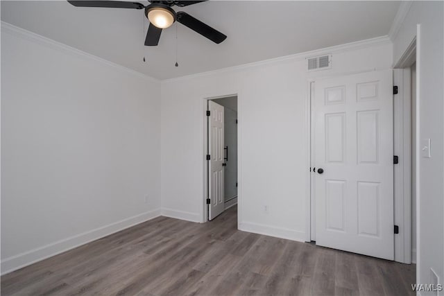 unfurnished bedroom with baseboards, visible vents, ceiling fan, wood finished floors, and crown molding