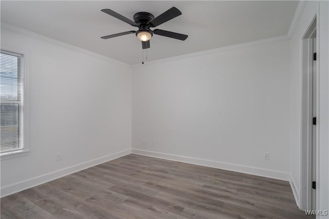 empty room featuring baseboards, ornamental molding, and wood finished floors