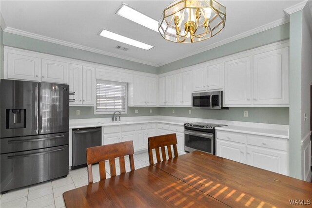 839 Seven Oaks Pl, Tuscaloosa, AL 35406 - kitchen with appliances with stainless steel finishes, light tile patterned floors, a chandelier, crown molding, and white cabinetry