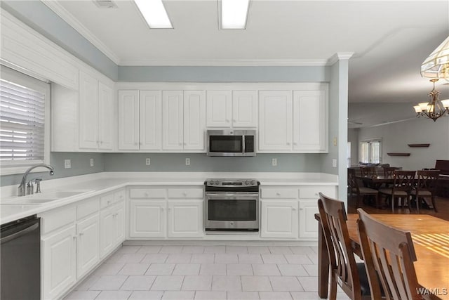 839 Seven Oaks Pl, Tuscaloosa, AL 35406 - kitchen featuring stainless steel appliances, white cabinets, a chandelier, and ornamental molding