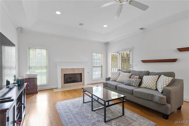 839 Seven Oaks Pl, Tuscaloosa, AL 35406 - living area with a raised ceiling, light wood finished floors, a tile fireplace, a ceiling fan, and recessed lighting