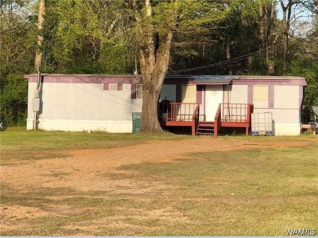 rear view of property featuring a deck and a yard