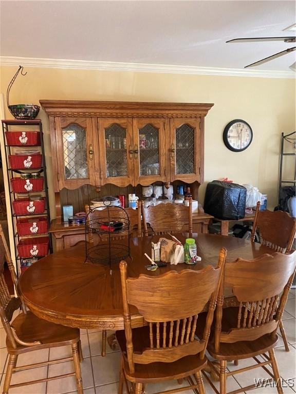 dining room featuring light tile patterned floors, a ceiling fan, and crown molding