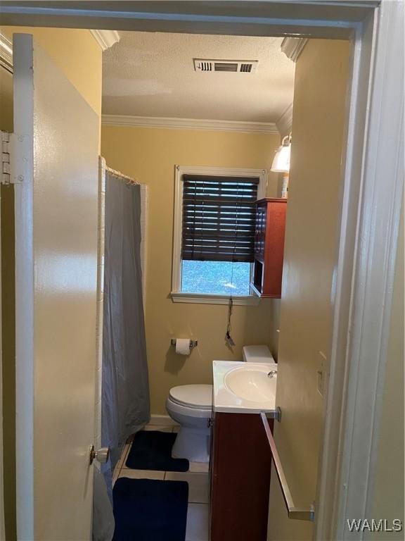 full bath featuring toilet, vanity, visible vents, ornamental molding, and tile patterned floors