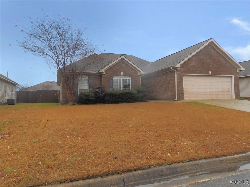 ranch-style home with a garage and central AC unit