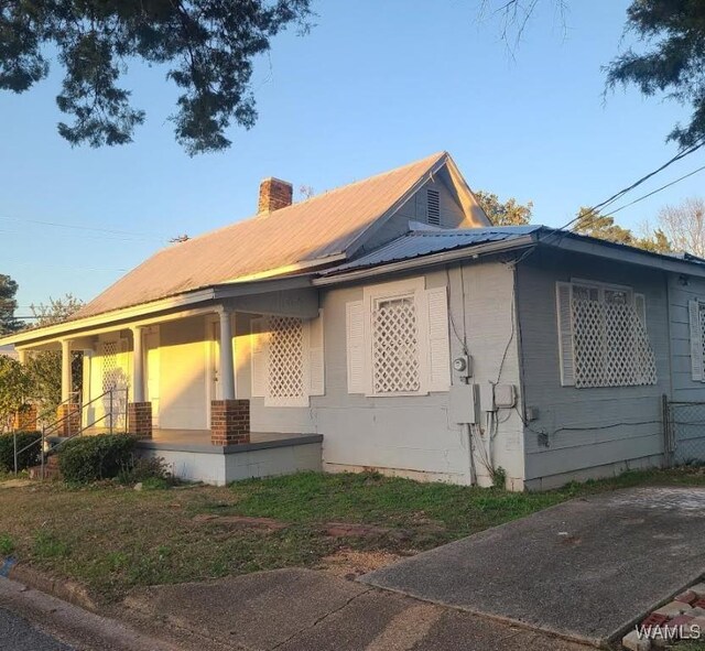 1923 18th Ave, Northport, AL 35476 - view of property exterior featuring a chimney, a porch, and metal roof