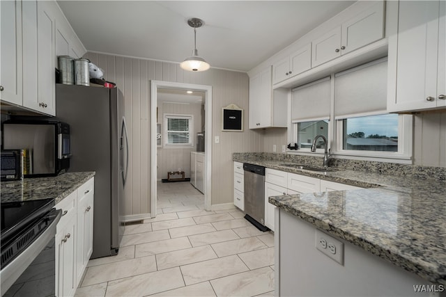 kitchen featuring pendant lighting, sink, stone countertops, white cabinetry, and stainless steel appliances