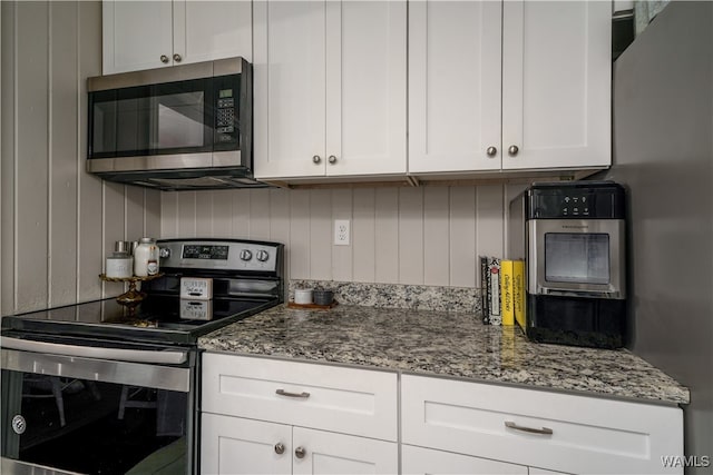 kitchen featuring light stone countertops, white cabinets, and appliances with stainless steel finishes