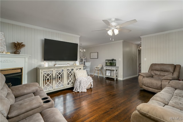 living room with ceiling fan with notable chandelier, ornamental molding, dark wood-type flooring, and wooden walls