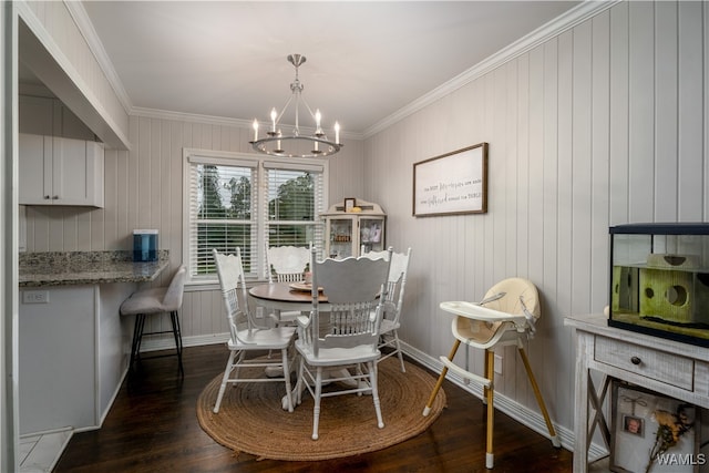 dining room with dark hardwood / wood-style flooring, an inviting chandelier, crown molding, and wood walls