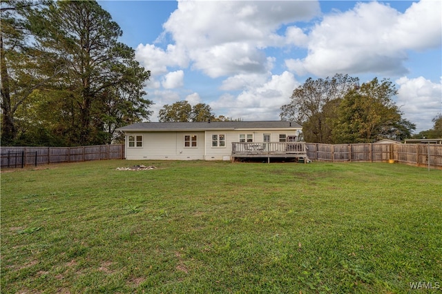 back of property with a yard and a wooden deck