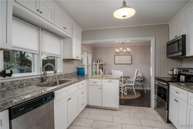 kitchen with white cabinetry, pendant lighting, and stainless steel appliances