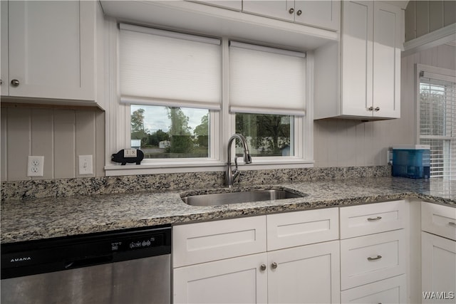 kitchen featuring stainless steel dishwasher, light stone countertops, white cabinetry, and sink