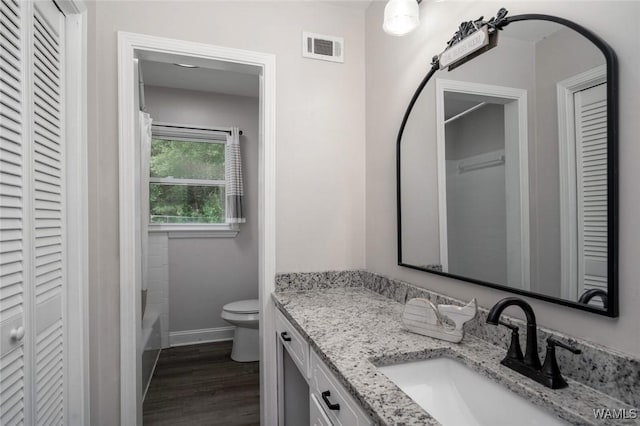 15120 Lakeland Forest Dr, Northport, AL 35475 - full bathroom featuring a closet, vanity, toilet, baseboards, and wood finished floors