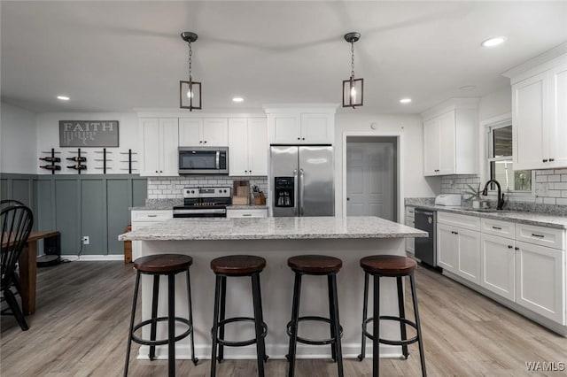 15120 Lakeland Forest Dr, Northport, AL 35475 - kitchen with stainless steel appliances, a sink, tasteful backsplash, a center island, and white cabinetry