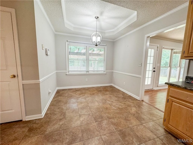 unfurnished dining area featuring a raised ceiling, crown molding, a textured ceiling, and a notable chandelier