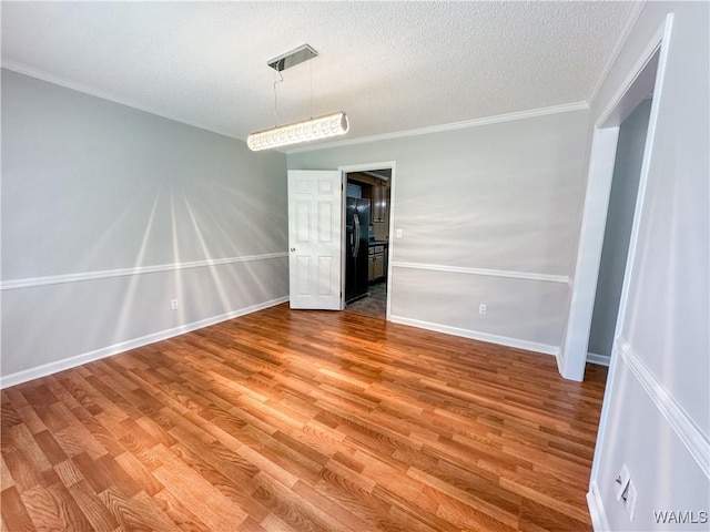 unfurnished room with crown molding, hardwood / wood-style floors, and a textured ceiling