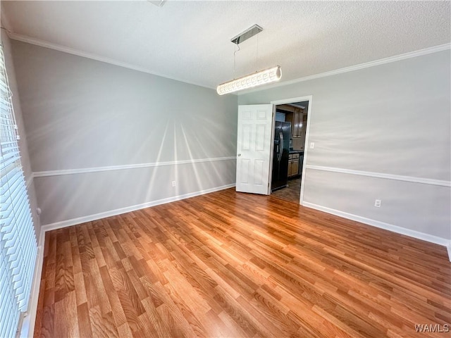 spare room featuring hardwood / wood-style flooring and crown molding