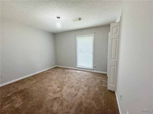 carpeted spare room featuring a textured ceiling