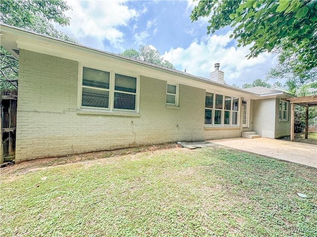 back of house with a patio area and a yard