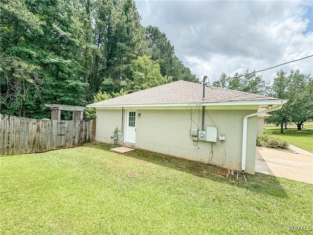 view of side of home with a yard