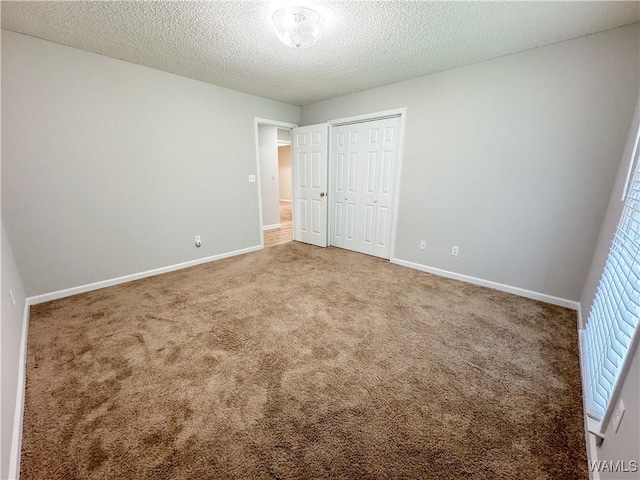 unfurnished bedroom featuring a closet, carpet, and a textured ceiling