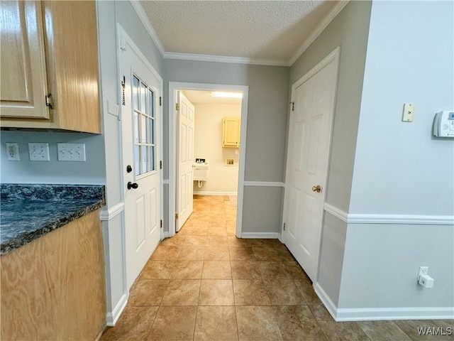 corridor featuring a textured ceiling, ornamental molding, and light tile patterned flooring