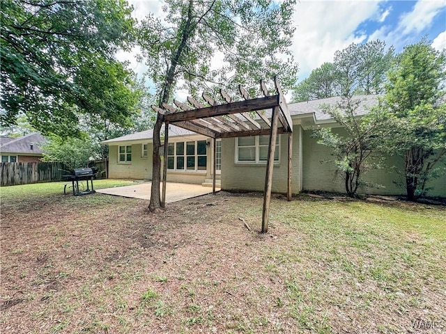 rear view of house with a pergola, a patio, and a lawn