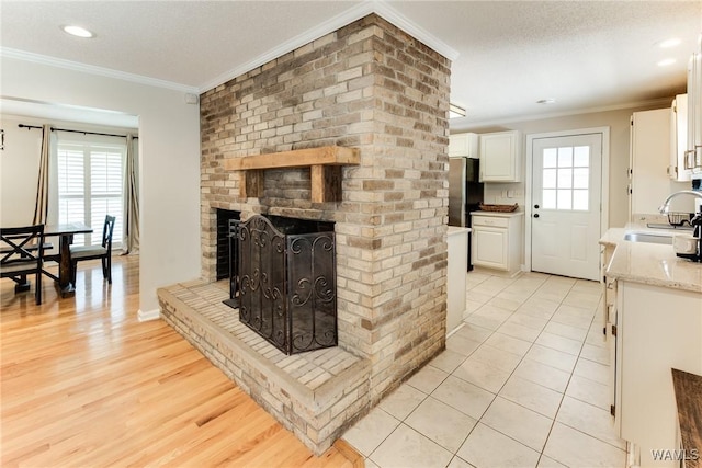 4809 Dove Creek Ave, Northport, AL 35473 - living area with crown molding, a brick fireplace, light wood-style floors, and recessed lighting