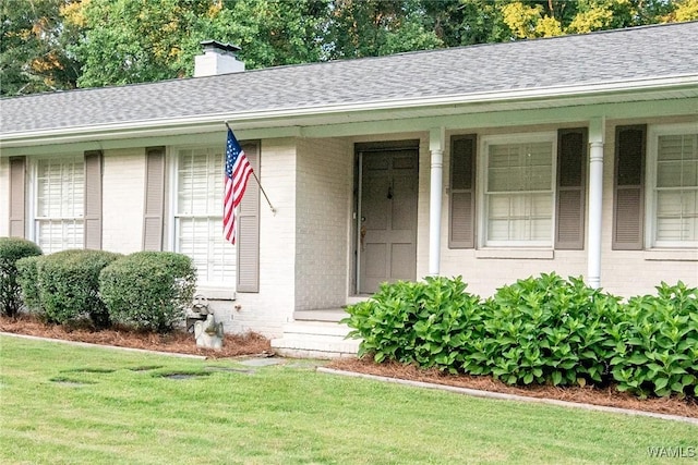 4809 Dove Creek Ave, Northport, AL 35473 - view of front facade with brick siding, a shingled roof, a front lawn, and a chimney