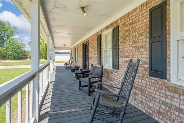 deck featuring a lawn and covered porch