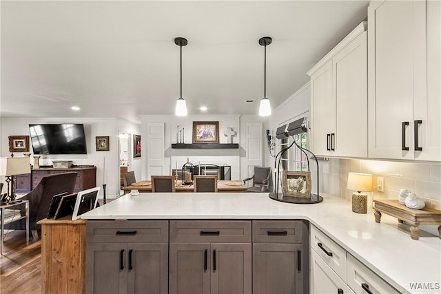 2507 Twin Mnr, Northport, AL 35476 - kitchen with a peninsula, open floor plan, light countertops, tasteful backsplash, and hanging light fixtures
