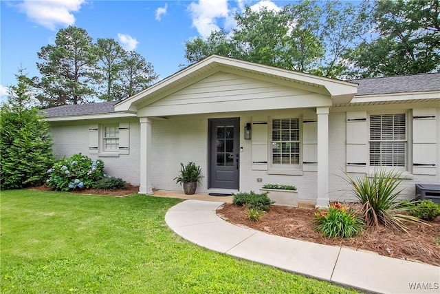 2507 Twin Mnr, Northport, AL 35476 - view of front of house featuring a front yard, brick siding, covered porch, and roof with shingles