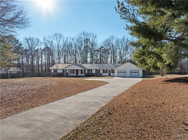 ranch-style house with concrete driveway, an attached garage, and fence