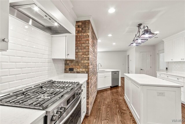 kitchen with custom exhaust hood, a center island, backsplash, white cabinets, and stainless steel appliances