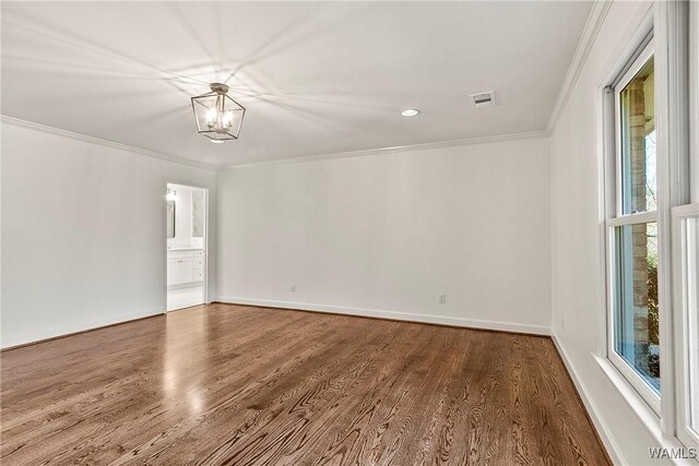 unfurnished room with a notable chandelier, wood-type flooring, and crown molding